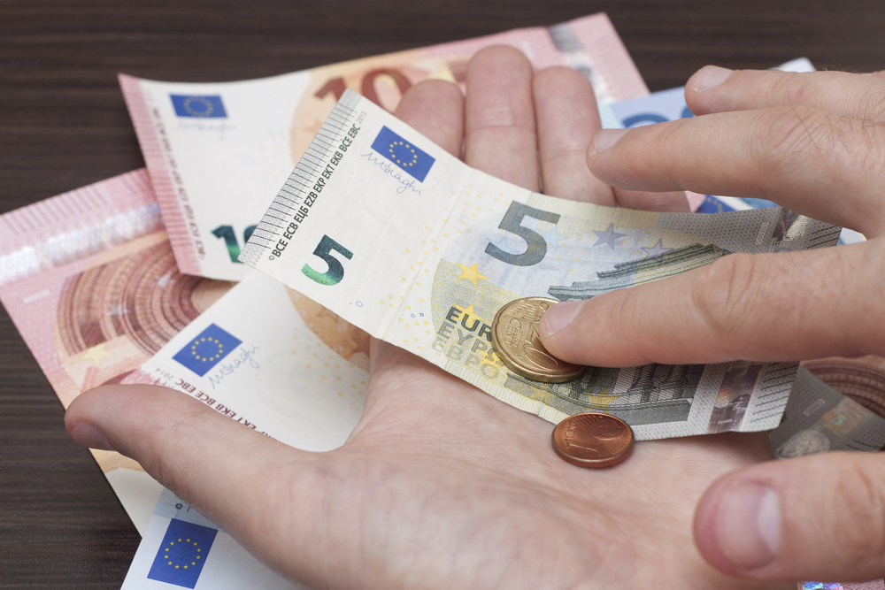 Euromuntstukken en -geldbriefjes in een open hand
