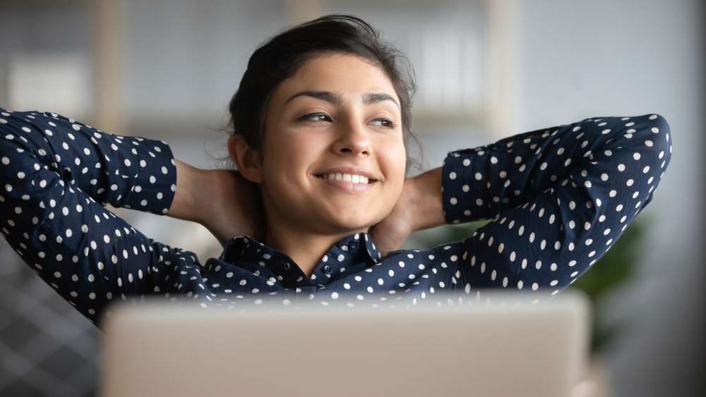 Vrouw leunt achterover bij een pc