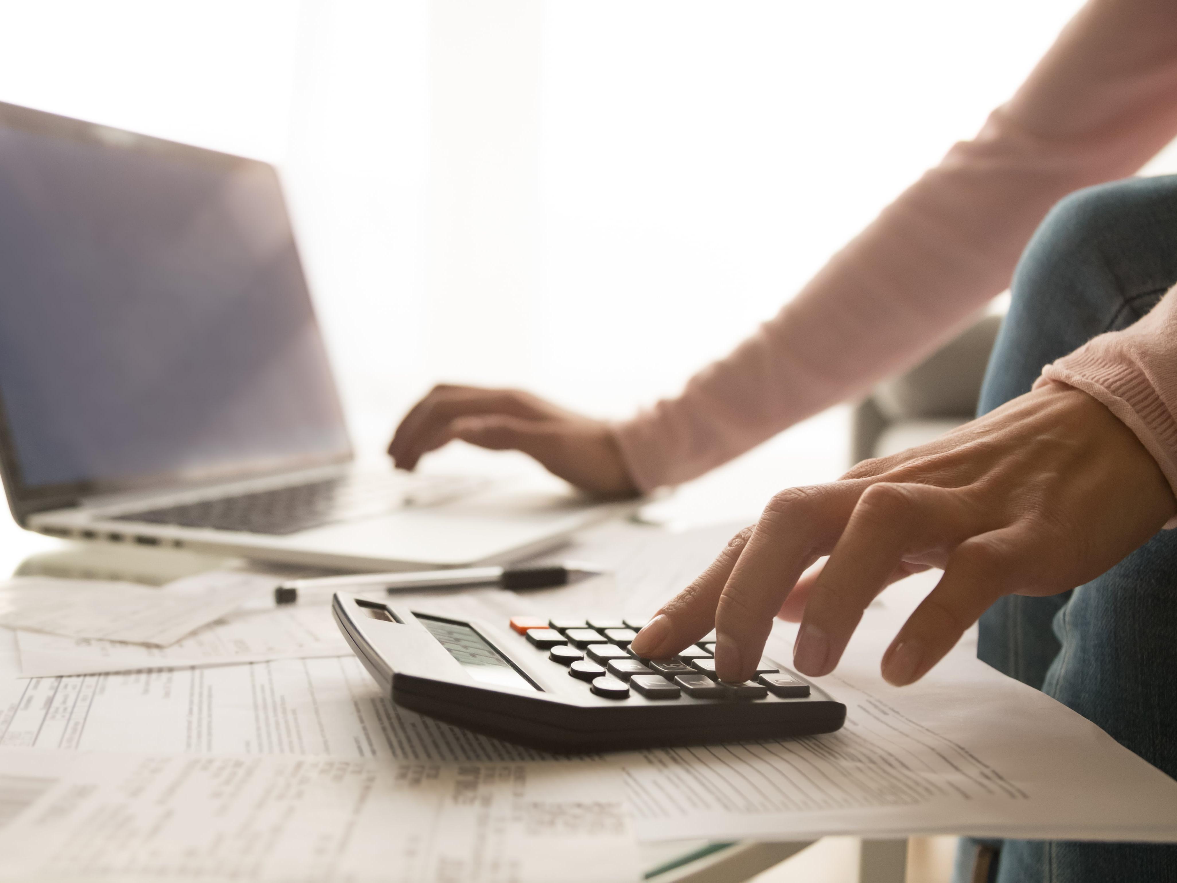 Homme avec ordinateur et calculatrice