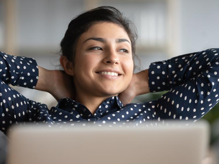 Vrouw leunt achterover bij een pc