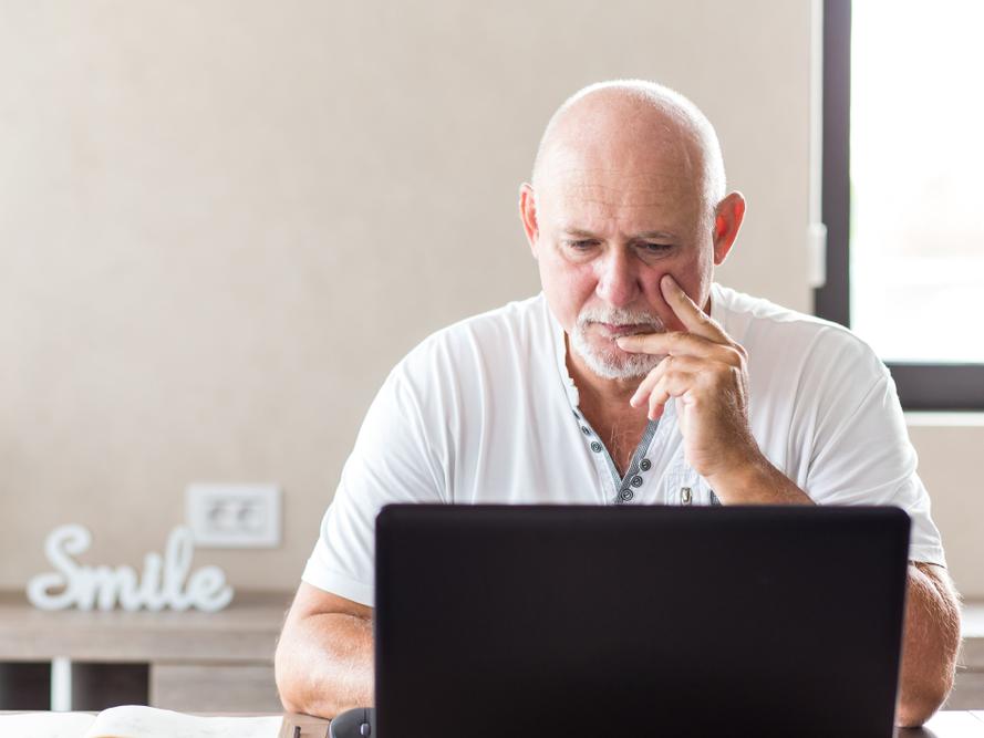 Oudere man werkt op een laptop