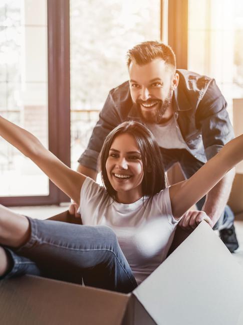 Vrouw in een verhuisdoos geduwd door een man