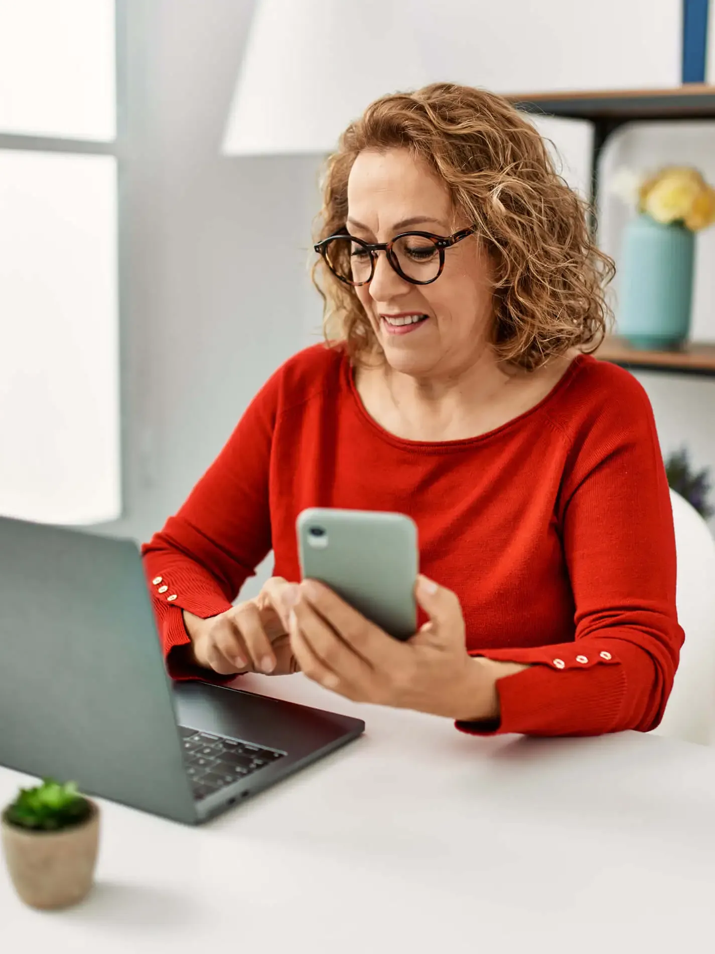 Femme sur son téléphone et son ordinateur