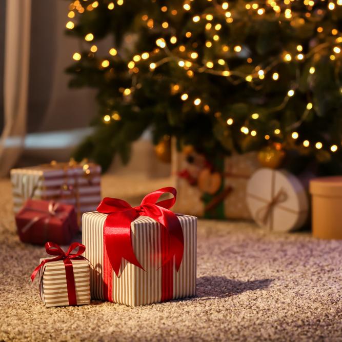 Cadeautjes onder een verlichte kerstboom