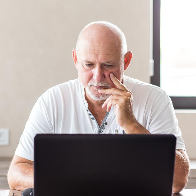 Oudere man werkt op een laptop