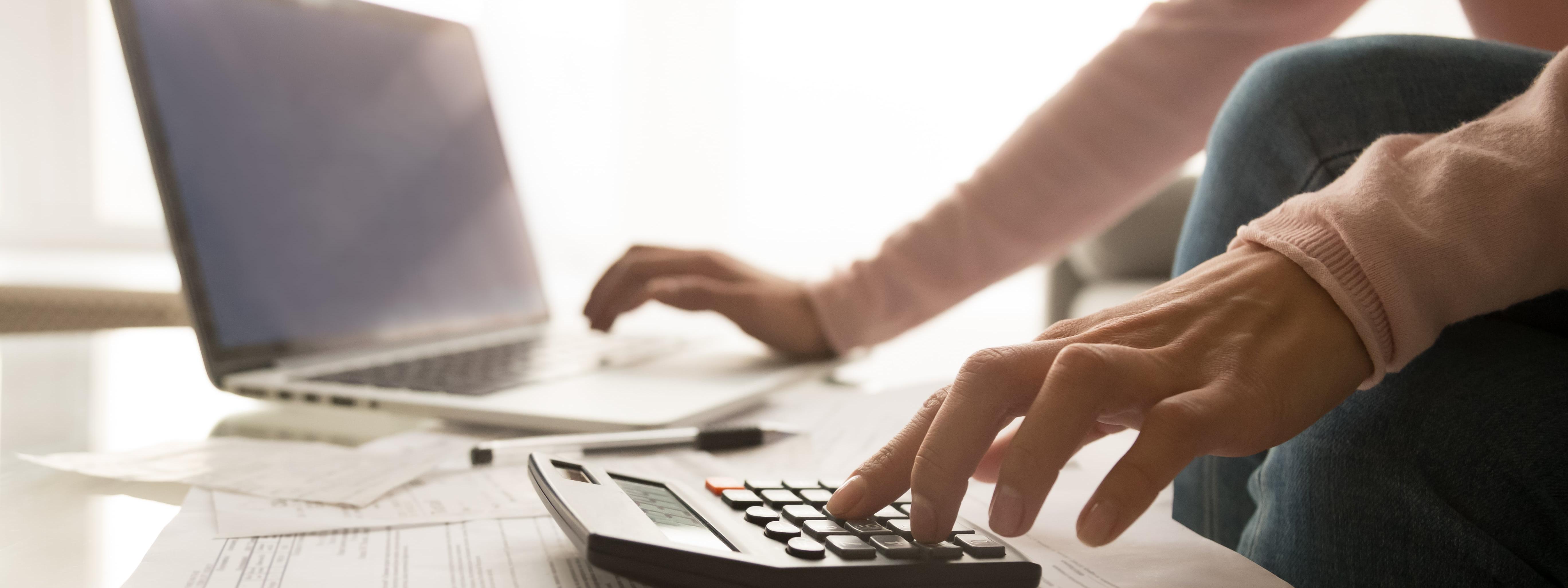Homme avec ordinateur et calculatrice