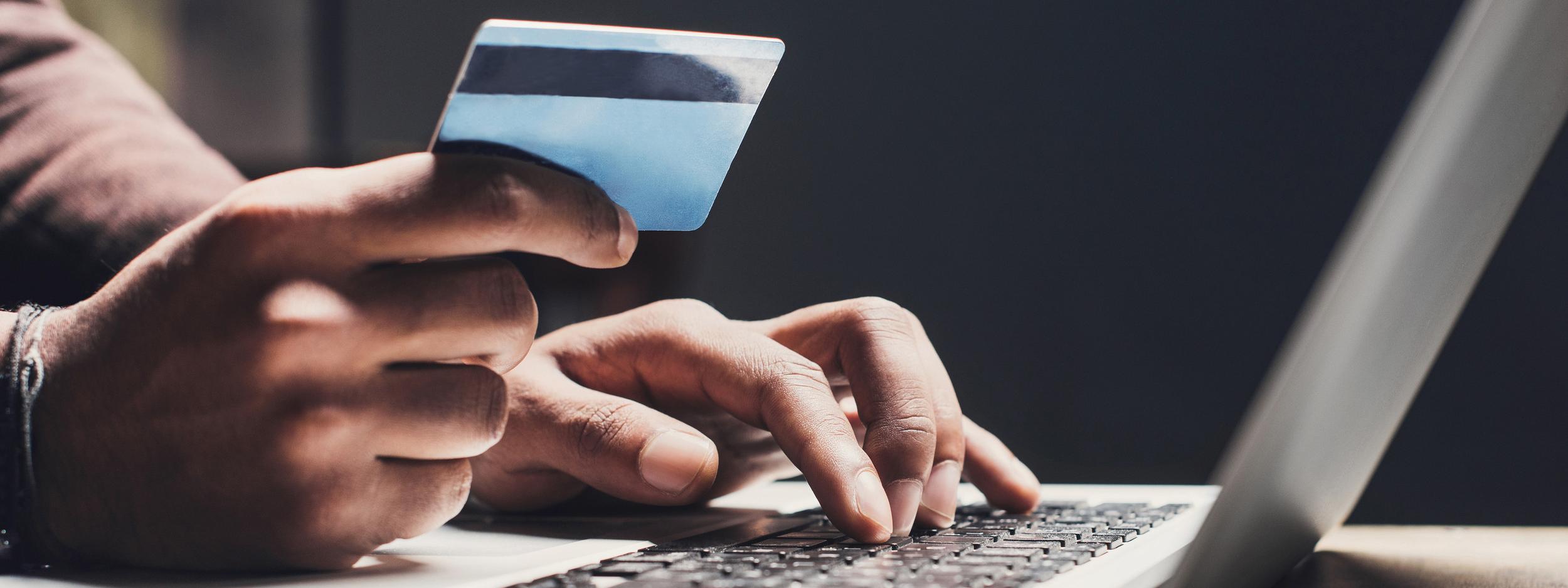 Man shopping online using laptop computer and credit card