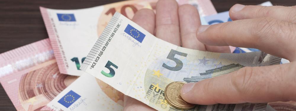 Euromuntstukken en -geldbriefjes in een open hand