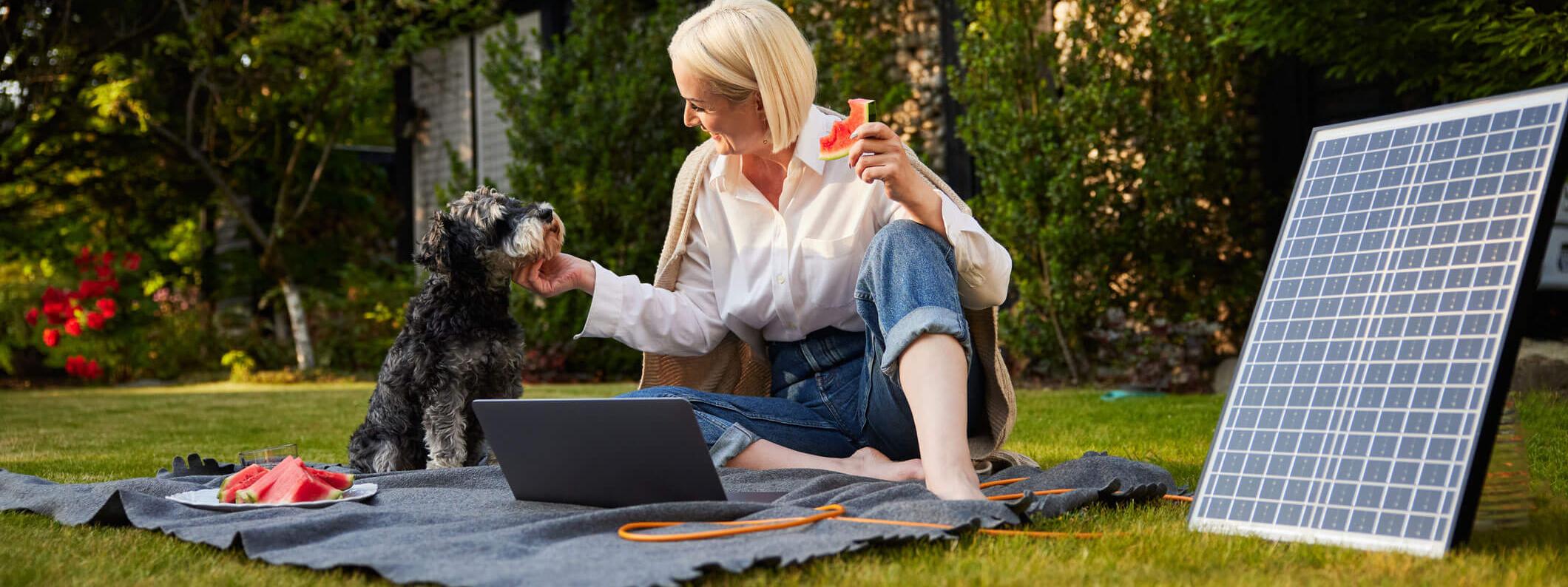 Een oudere dame die tevreden naar haar laptop kijkt, terwijl ze bankiert